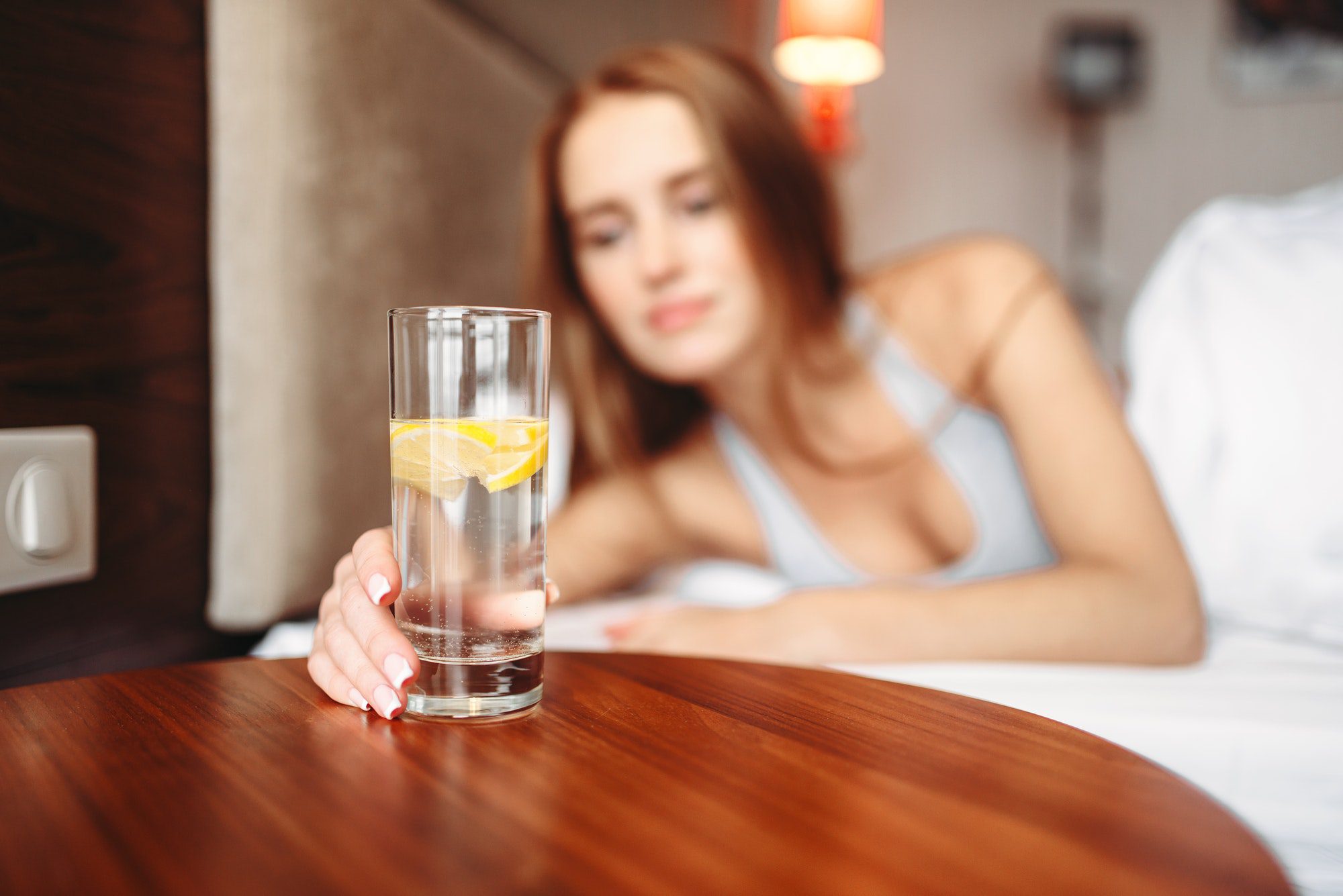 Female hand holds glass with lemon water