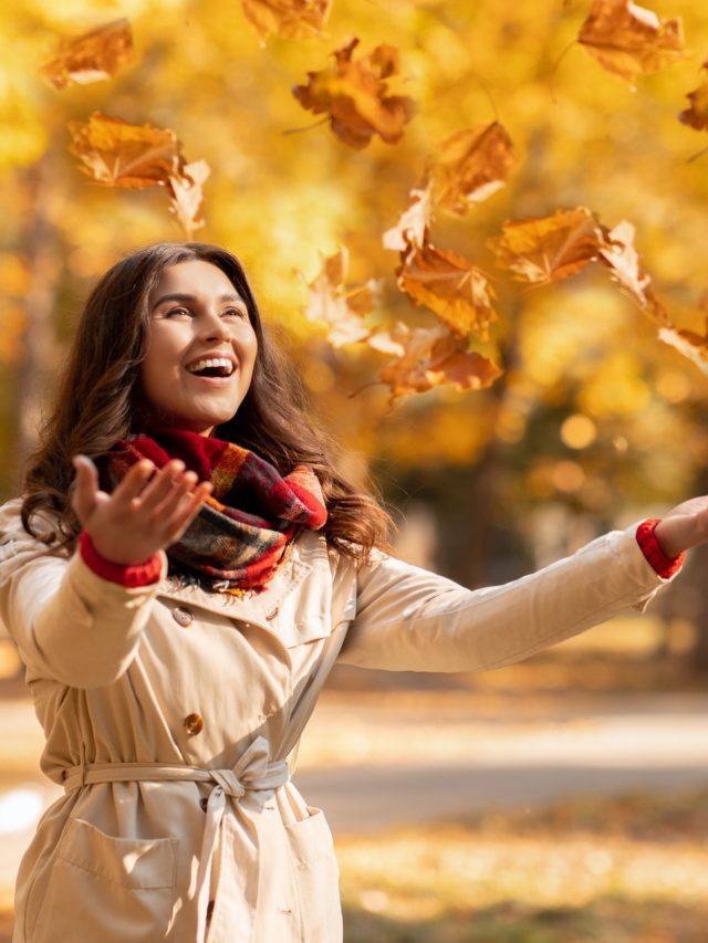 cropped-joyful-young-woman-in-autumn-outfit-catching-yellow-leaves-during-her-walk-at-park-on-bright-fall.jpg