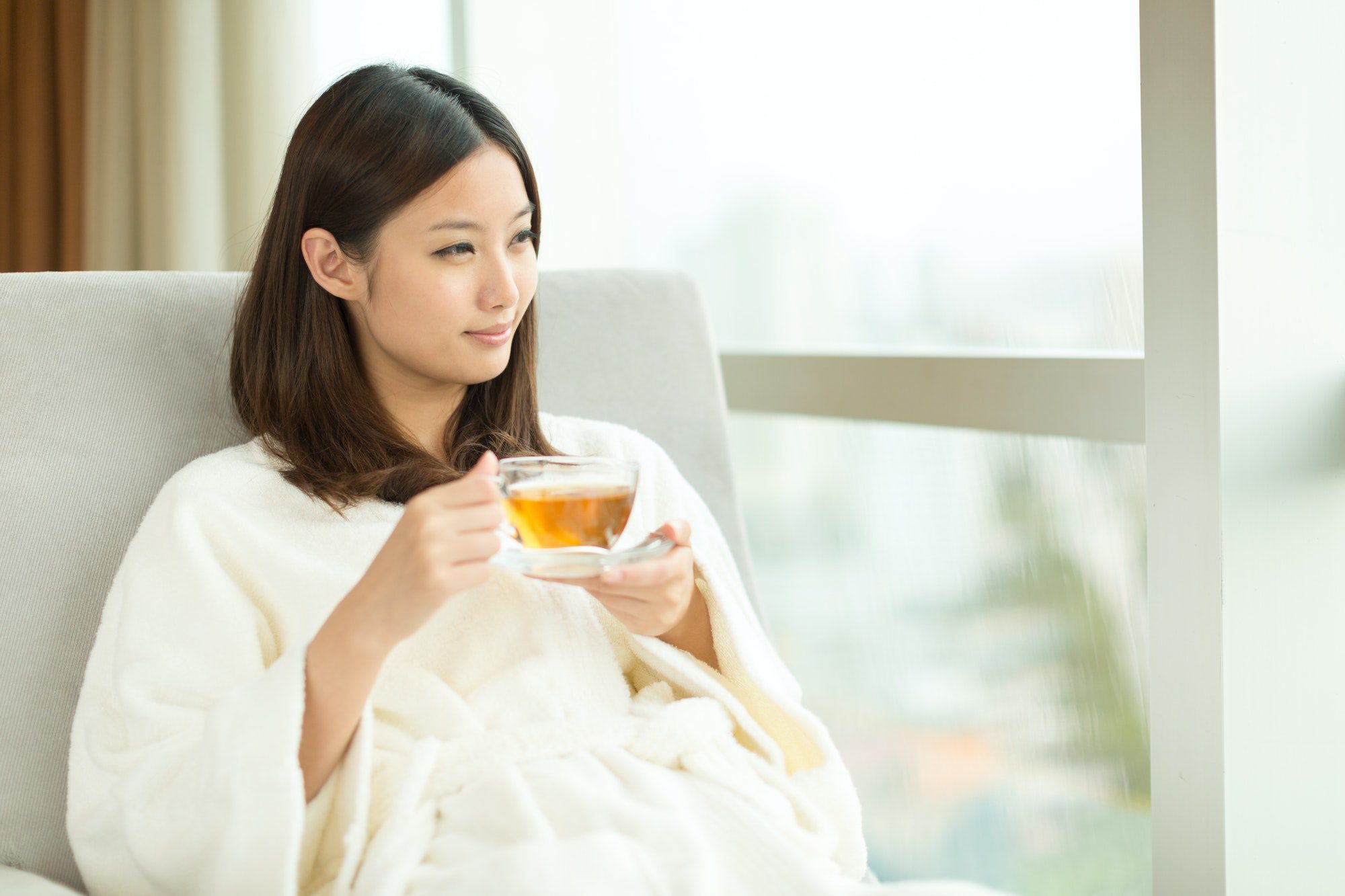 Pretty young girl drinking tea indoors