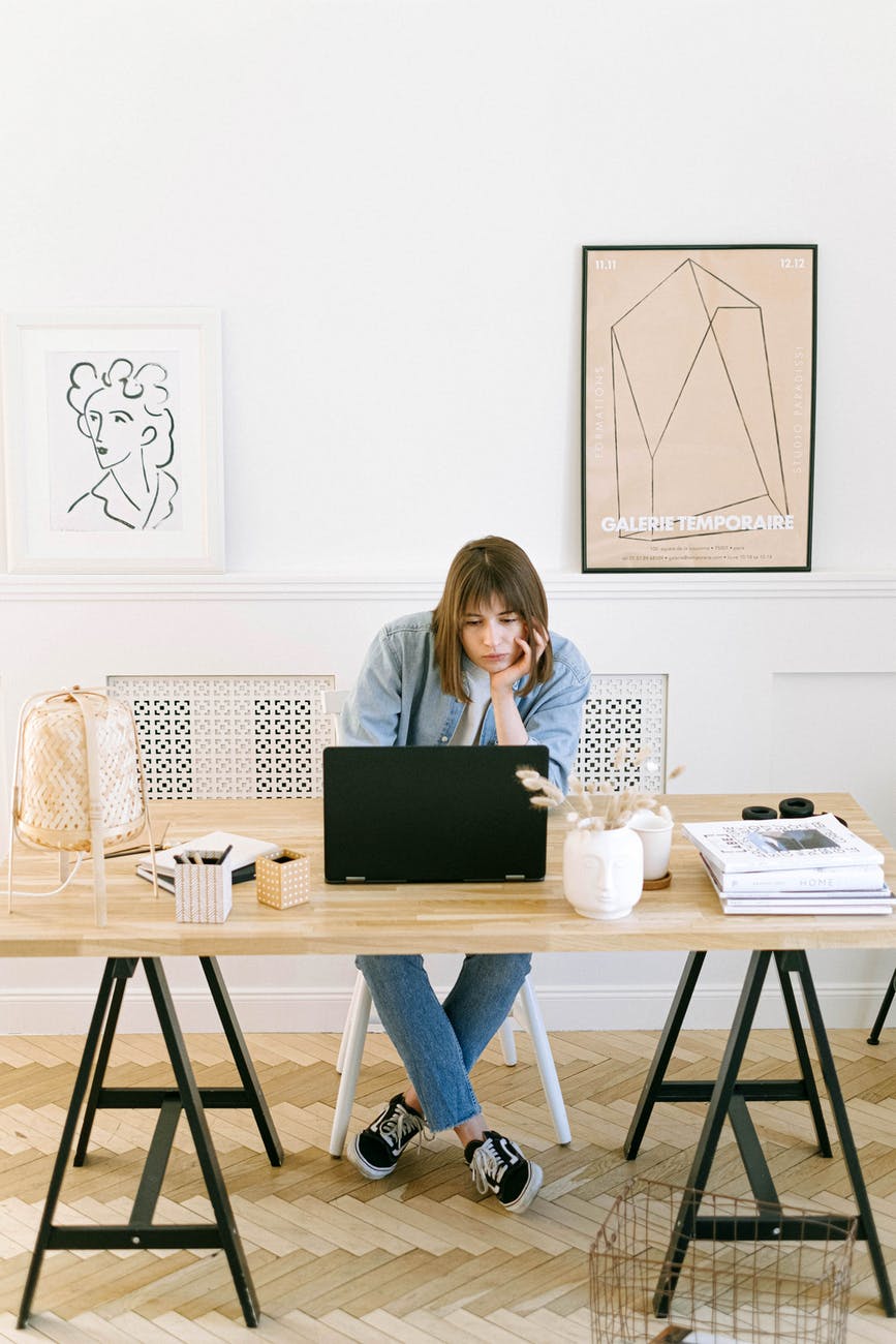 bored woman looking at a laptop