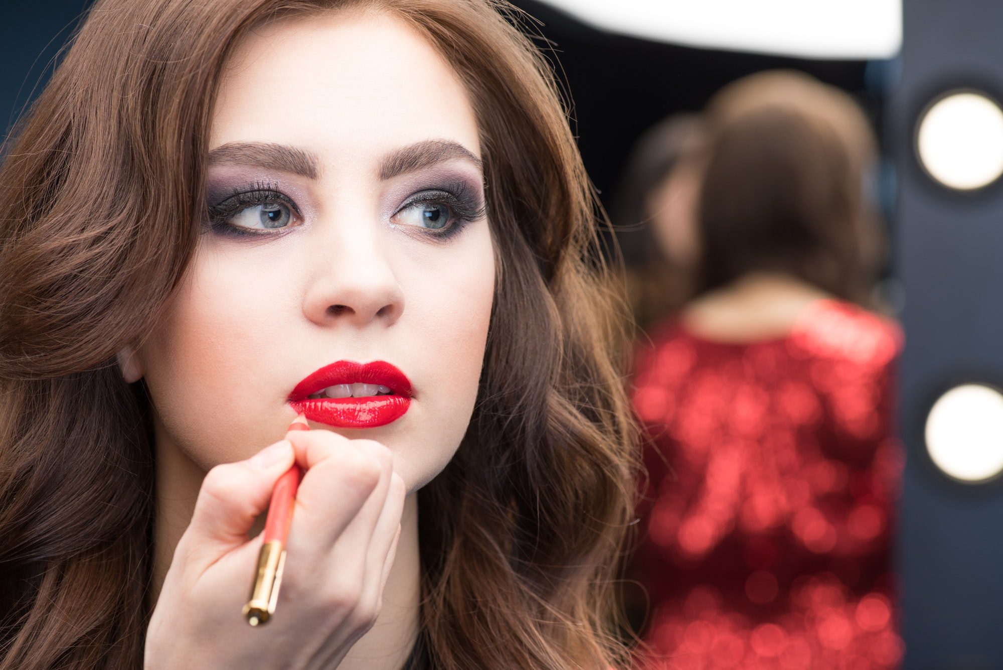 Make-up artist applying make-up to gorgeous young woman