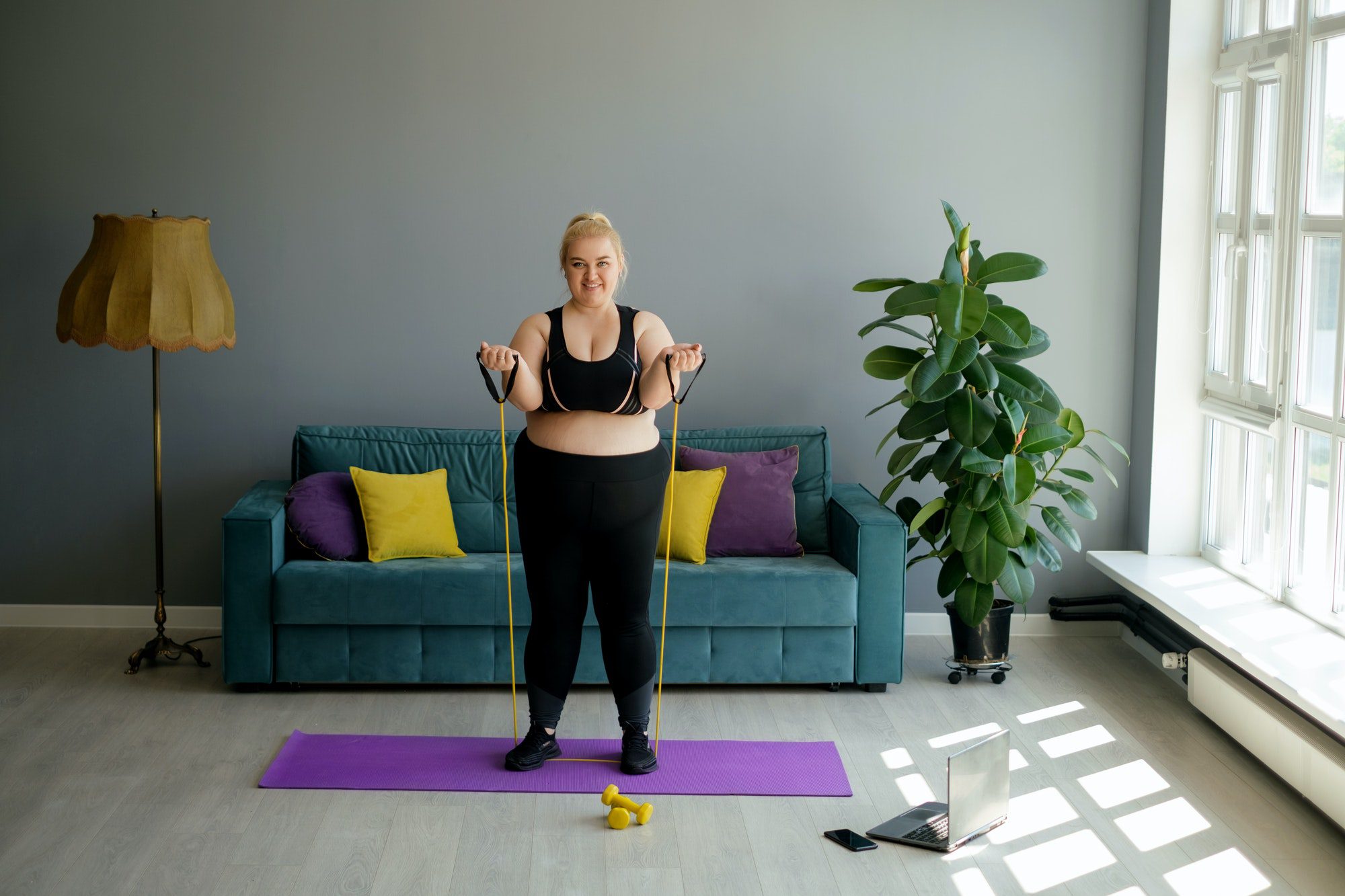 An obese overweight woman does an exercise using an expander.