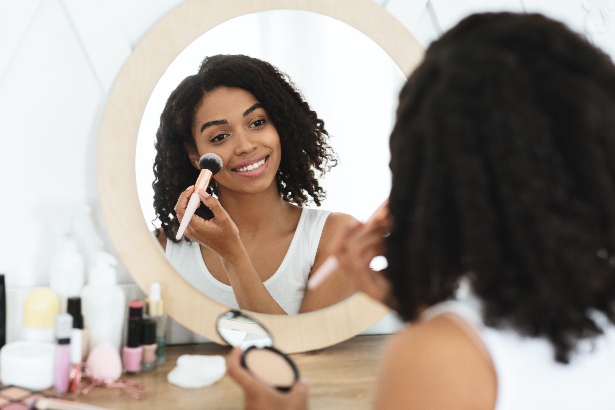 Nude Makeup. Smiling Black Girl Applying Blush On Cheeks With Brush