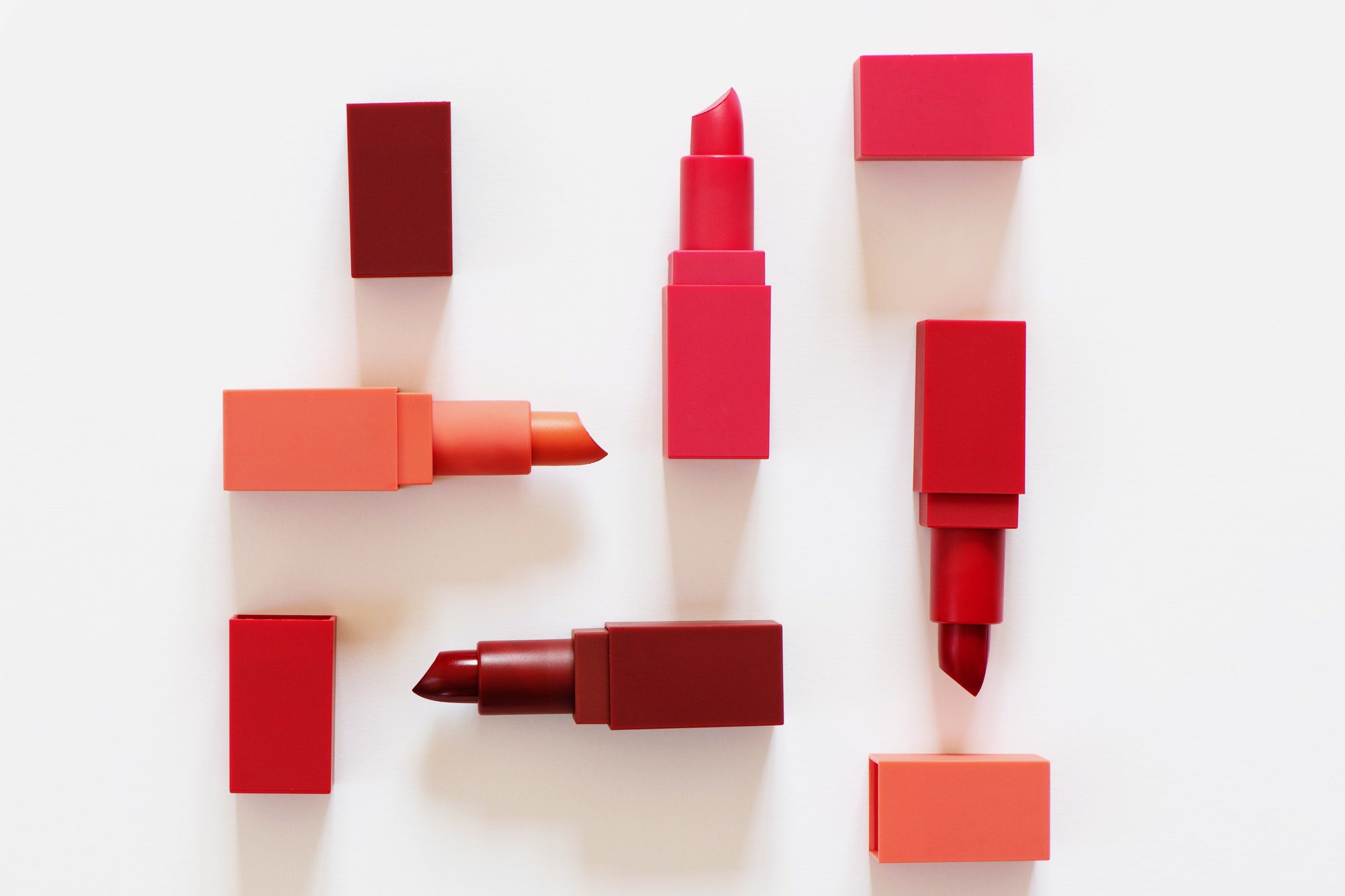 Top view of various lipsticks on white background. Flat lay.