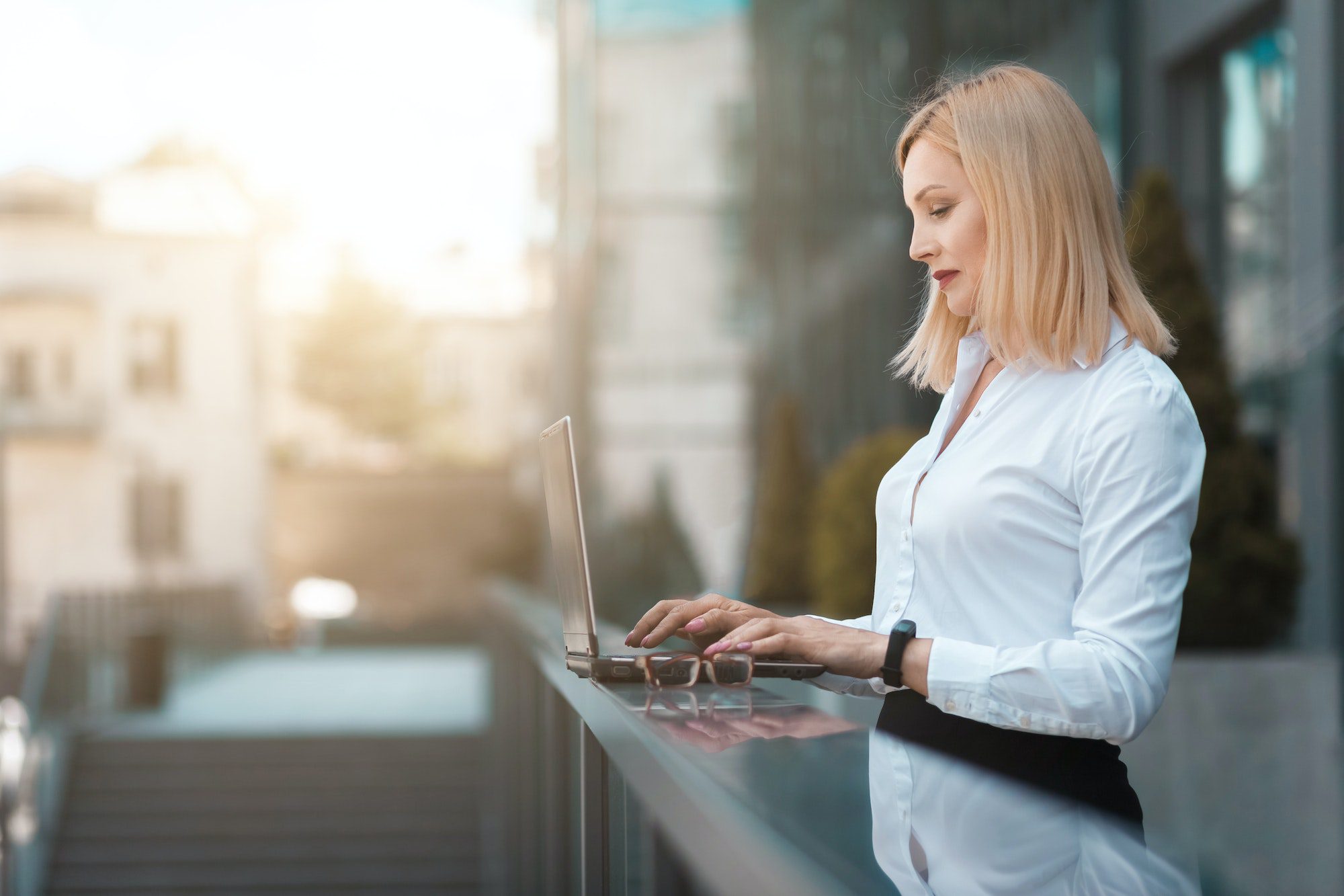 Business lady working on a laptop in the street