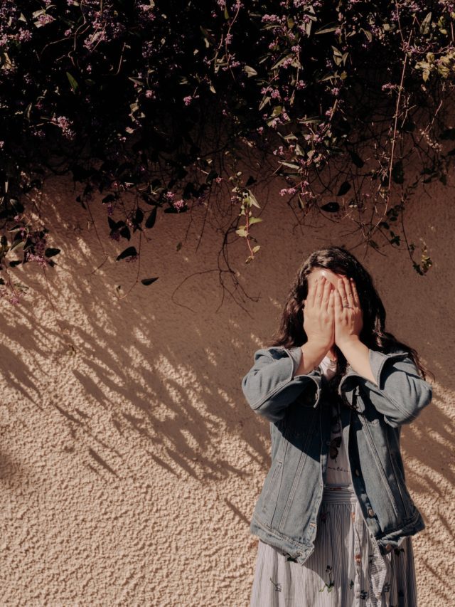 Woman covering her face from anxiety