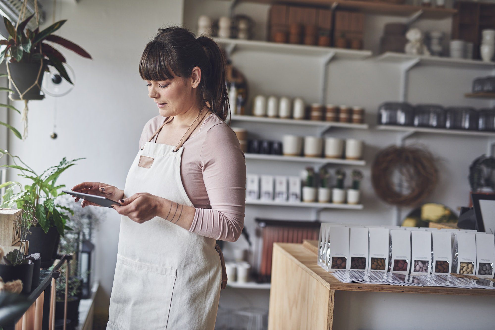 Florist working with a digital tablet in her flower shop