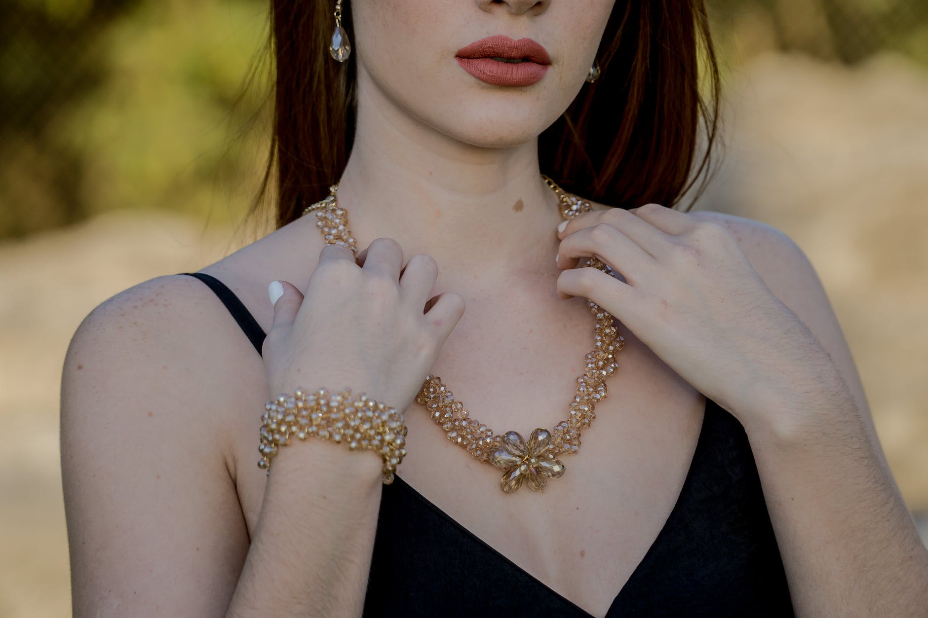 woman touching gold necklace