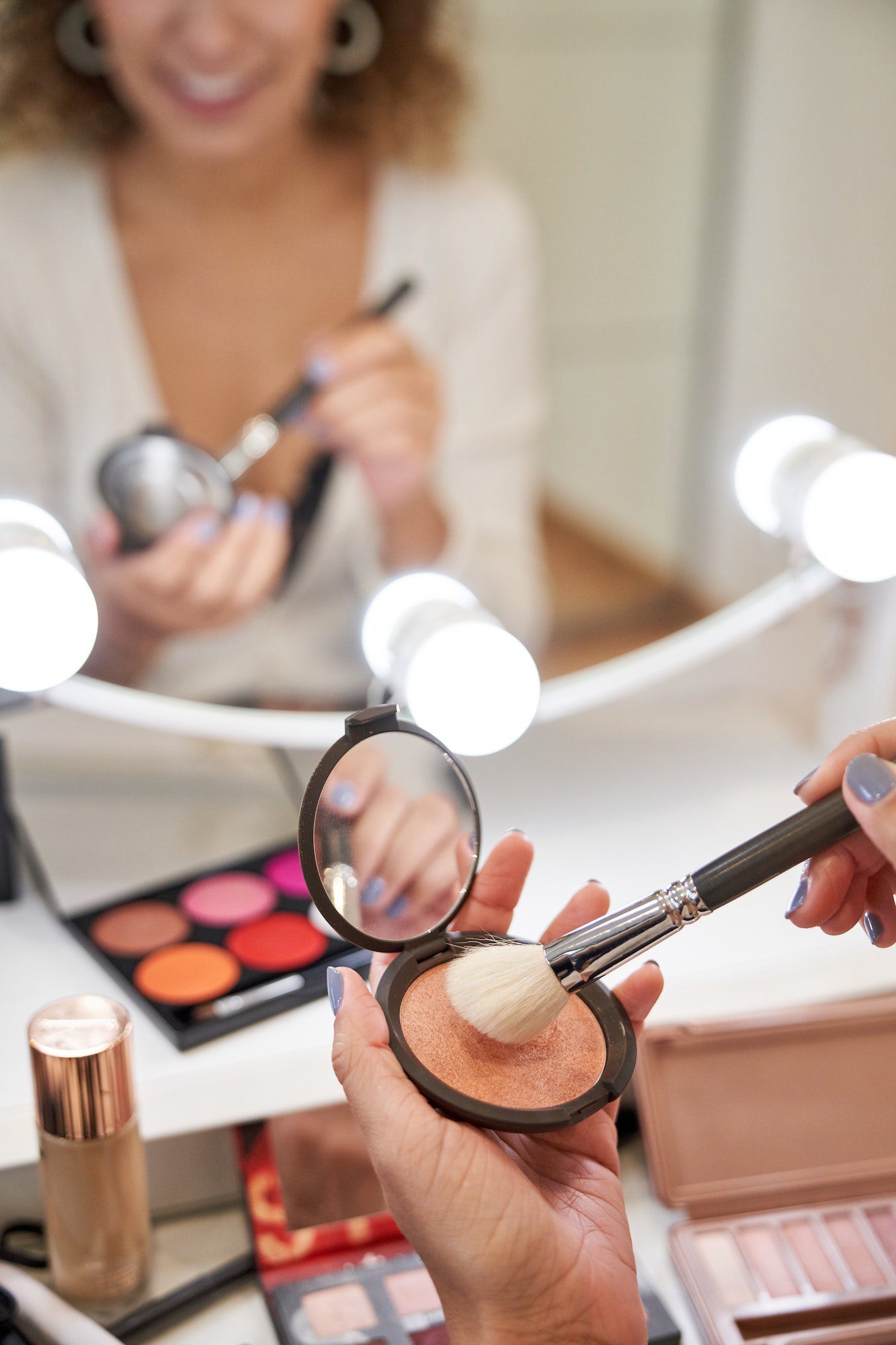 Crop visagiste woman taking dry blush for cheeks with brush