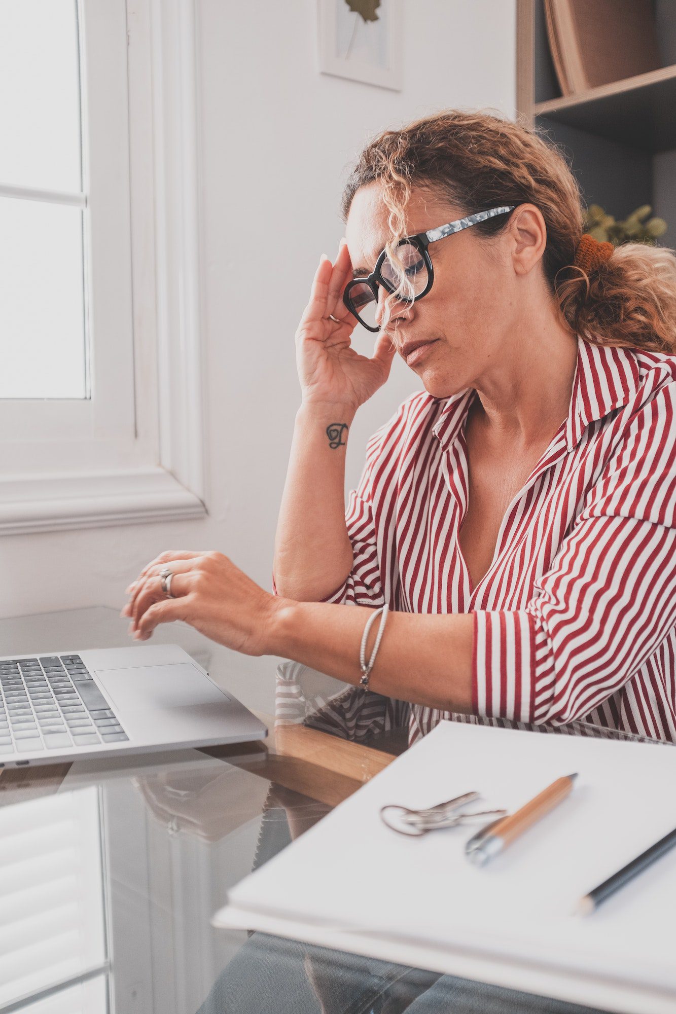 Unhealthy stressed businesswoman taking off eyeglasses, rubbing eyelids, suffering